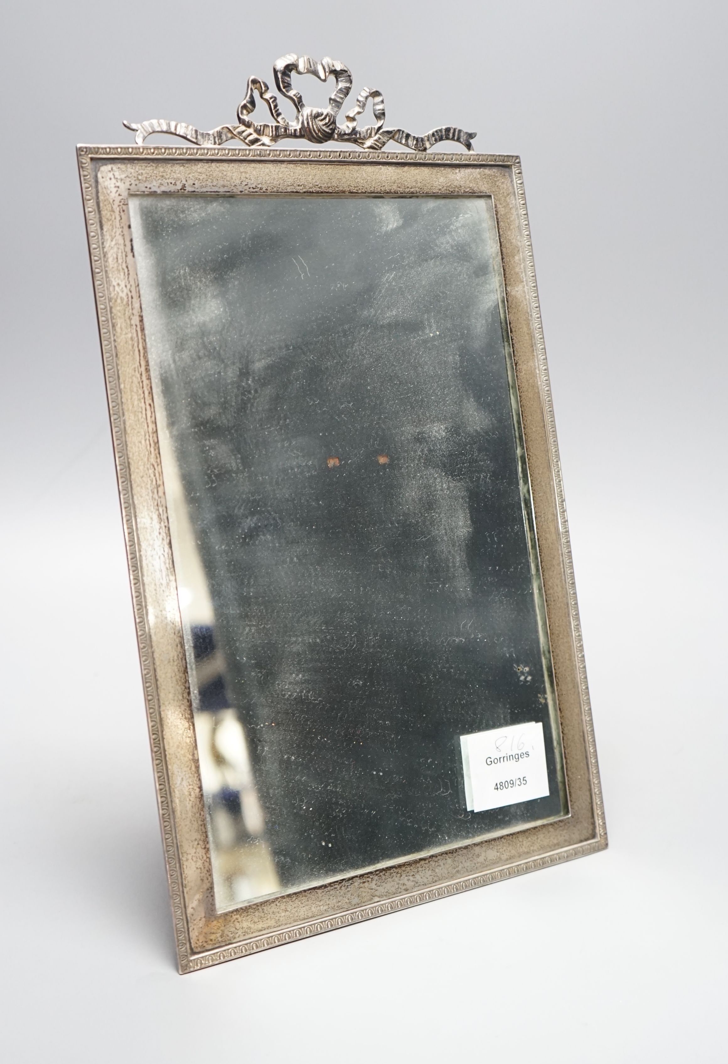 A George V silver mounted rectangular easel mirror, with ribbon bow crest, Stokes & Ireland Ltd, London, 1910, overall 35cm.